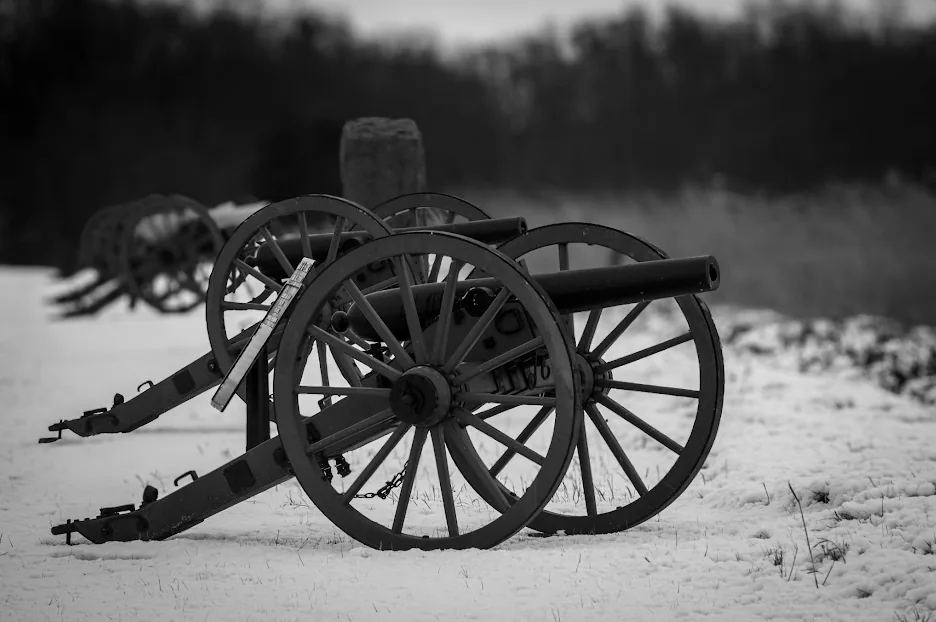 Black and white photo of Civil War cannons in the snow at Gettysburg